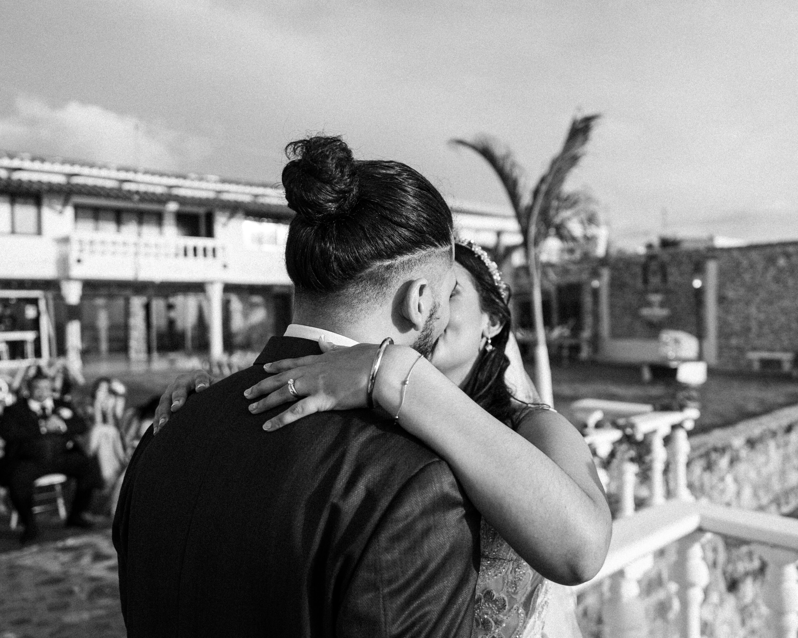 Der erste Kuss des Brautpaares bei der Hochzeitszeremonie in Schwarz Weis The Bride and Grooms First Kiss During the Wedding Ceremony in Black and White scaled