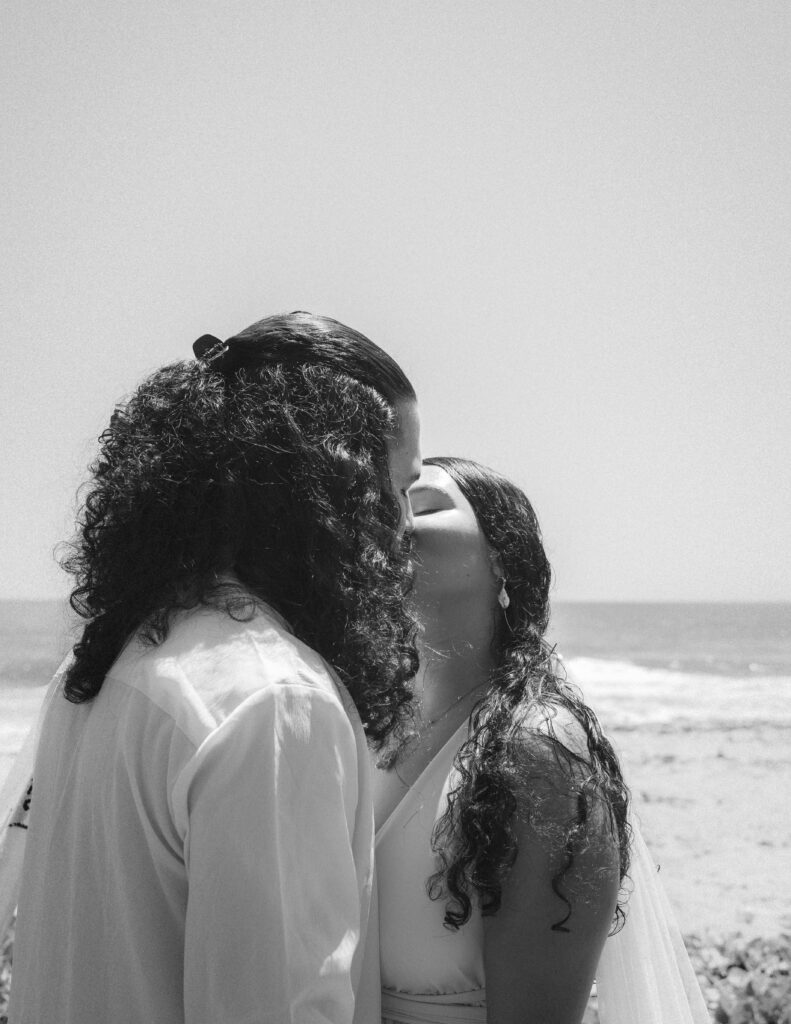 The couple shares a heartfelt kiss by the ocean during their elopement in Parque Tayrona, Colombia. A moment filled with love and connection, captured by Jan Schick. – Das Paar teilt einen innigen Kuss am Ozean während ihres Elopements im Parque Tayrona, Kolumbien. Ein Moment voller Liebe und Verbindung, festgehalten von Jan Schick.